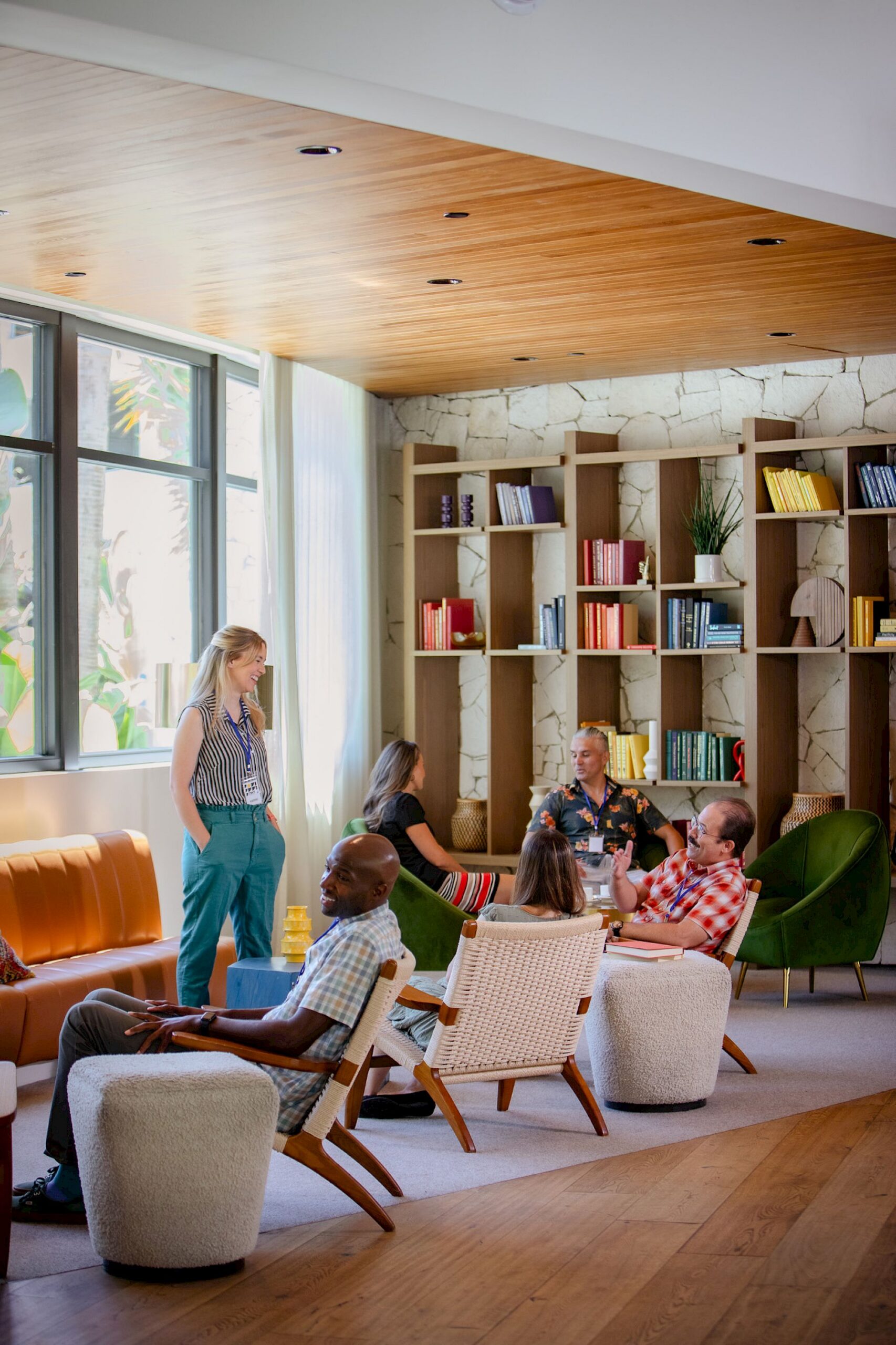 1o7a9272.2000x0 Conference attendees gathered in a colorful hotel ibrary and with green chairs