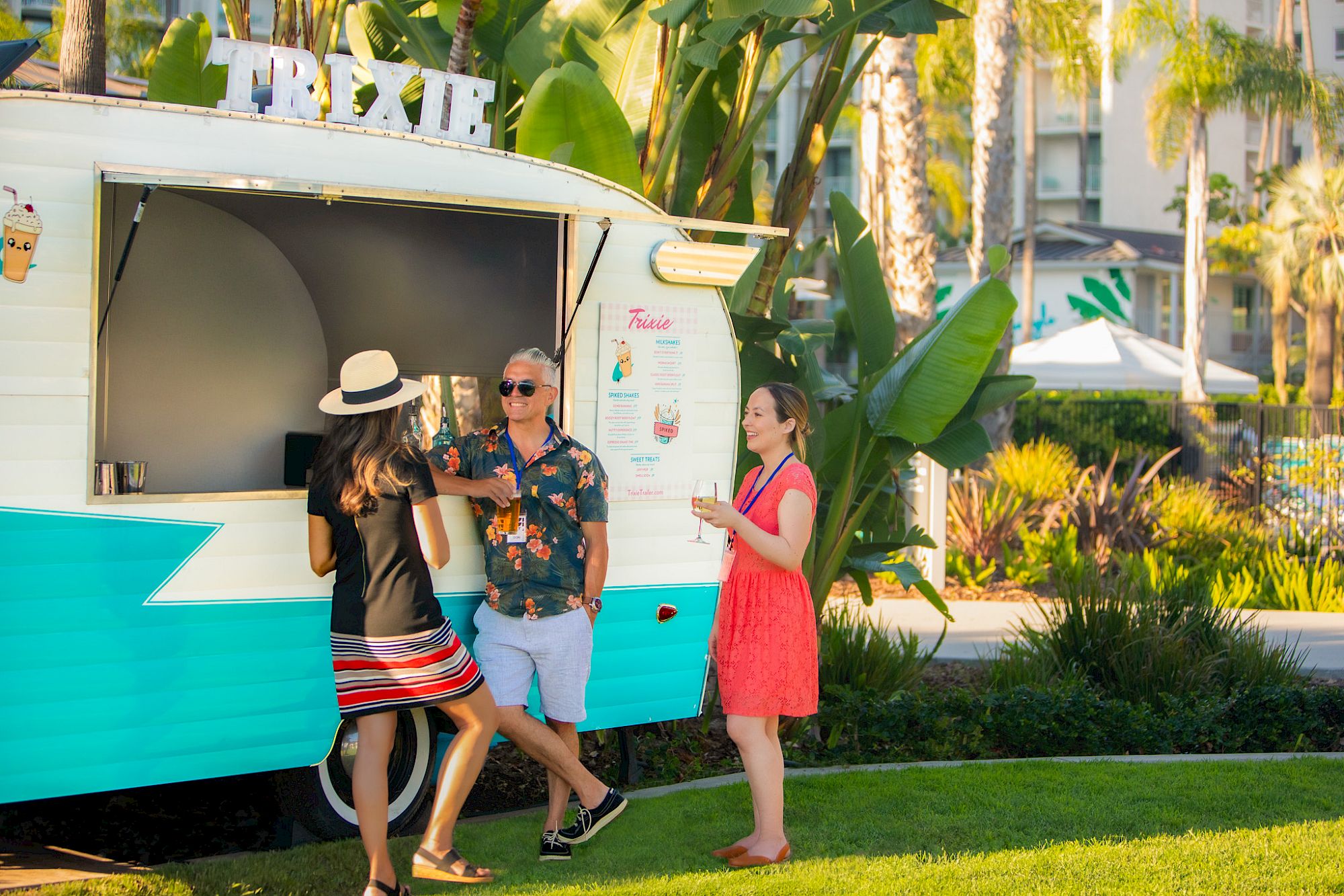 Three people standing next to a vintage food truck