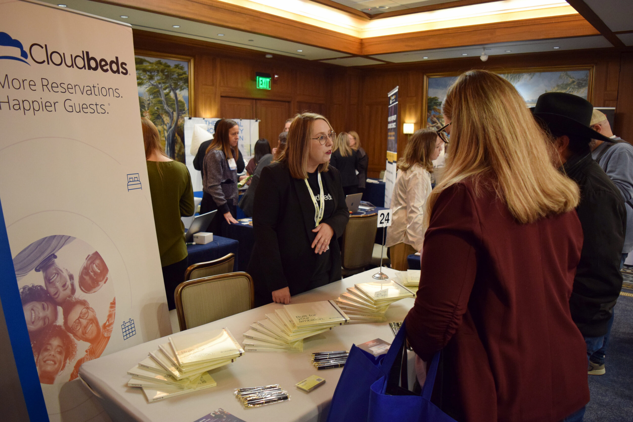 InnSpire26_ (45) A woman speaking with conference guests at trade show