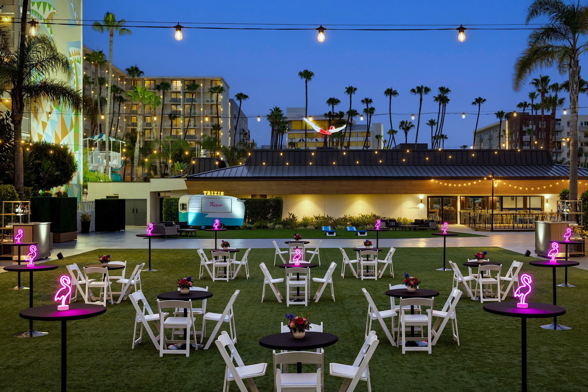 Outdoor lawn of hotel set up for a party with flamingo decorations